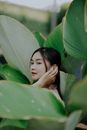 Woman Hiding Behind Green Leaf