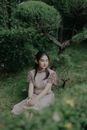 Woman in Brown Dress Sitting on Green Grass Field