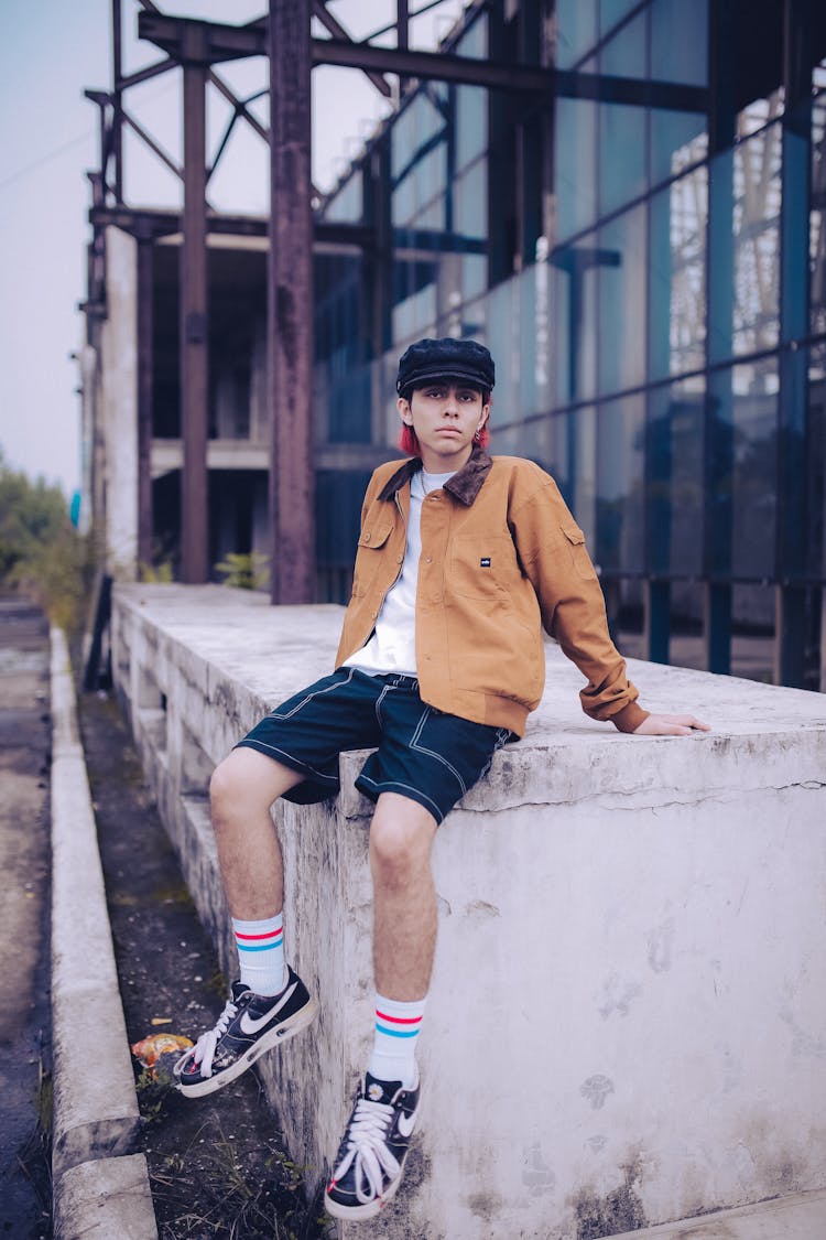 Young Fashion Model Sitting On Edge Of Industrial Building Foundation