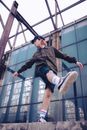 Man in Black Jacket and Blue Denim Shorts Jumping on Black Metal Railings