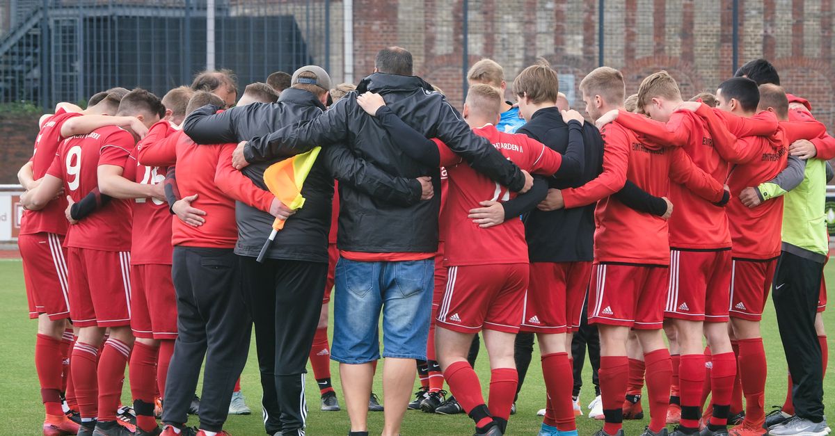 A team huddle with players focused and determined, hands in the center