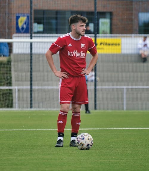 Player Standing Beside a Soccer Ball