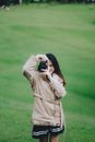 Woman in Brown Coat Holding Black Camera