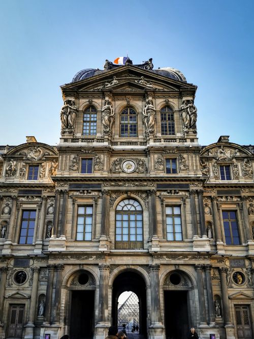 Free A stunning vertical shot of the Baroque architecture of the Louvre Museum in Paris under a clear blue sky. Stock Photo