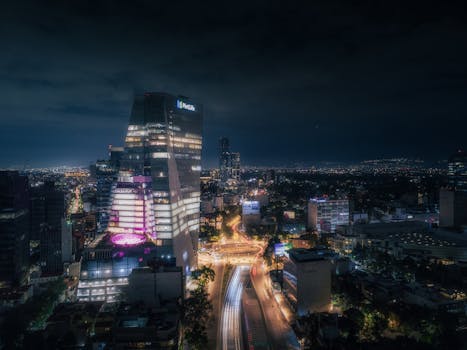 Stunning aerial shot of Mexico City at night showcasing illuminated buildings and light trails.