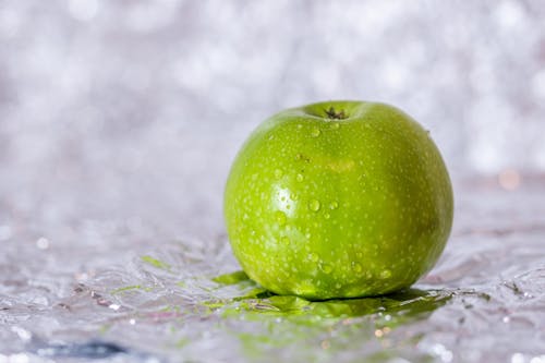 Free Green Apple on White Textile Stock Photo