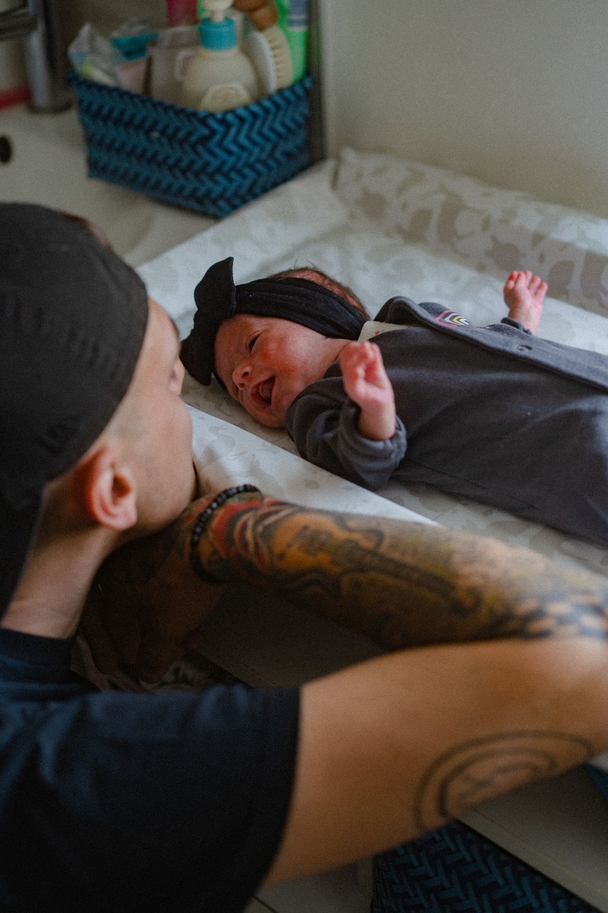 A father smiling down at his newborn baby in a nursery