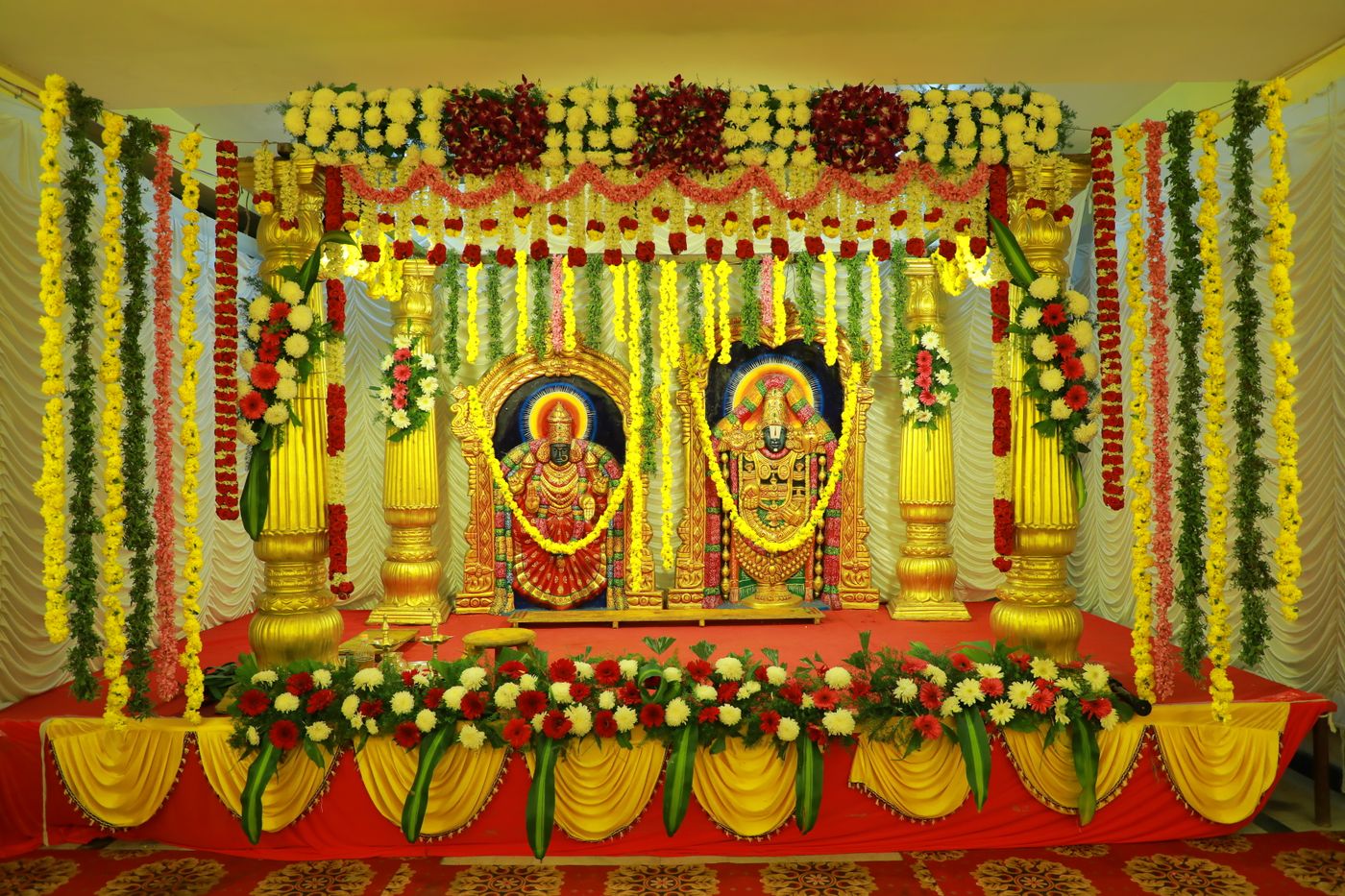 South Indian wedding mandap dressed in marigold between gilded columns — representative image
