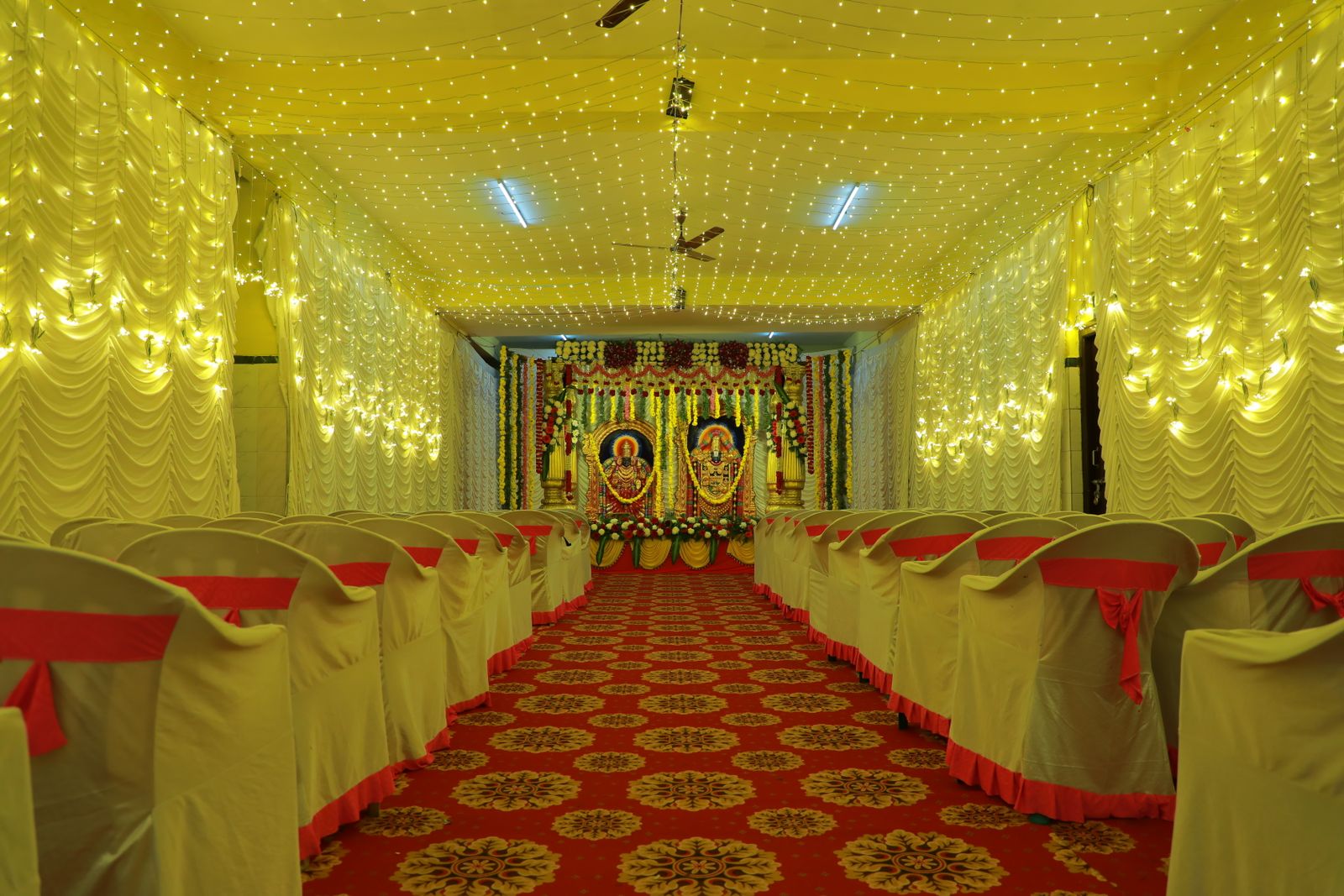 Hall set with ribboned chairs facing an illuminated stage