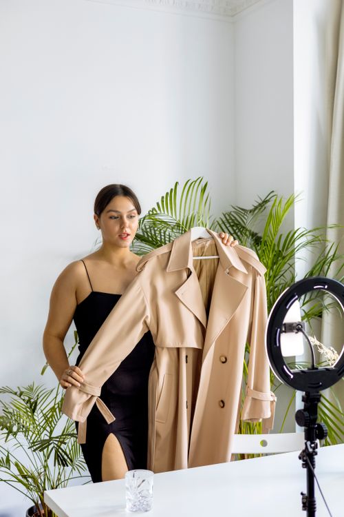 A Woman Holding Brown Trench Coat · Free Stock Photo