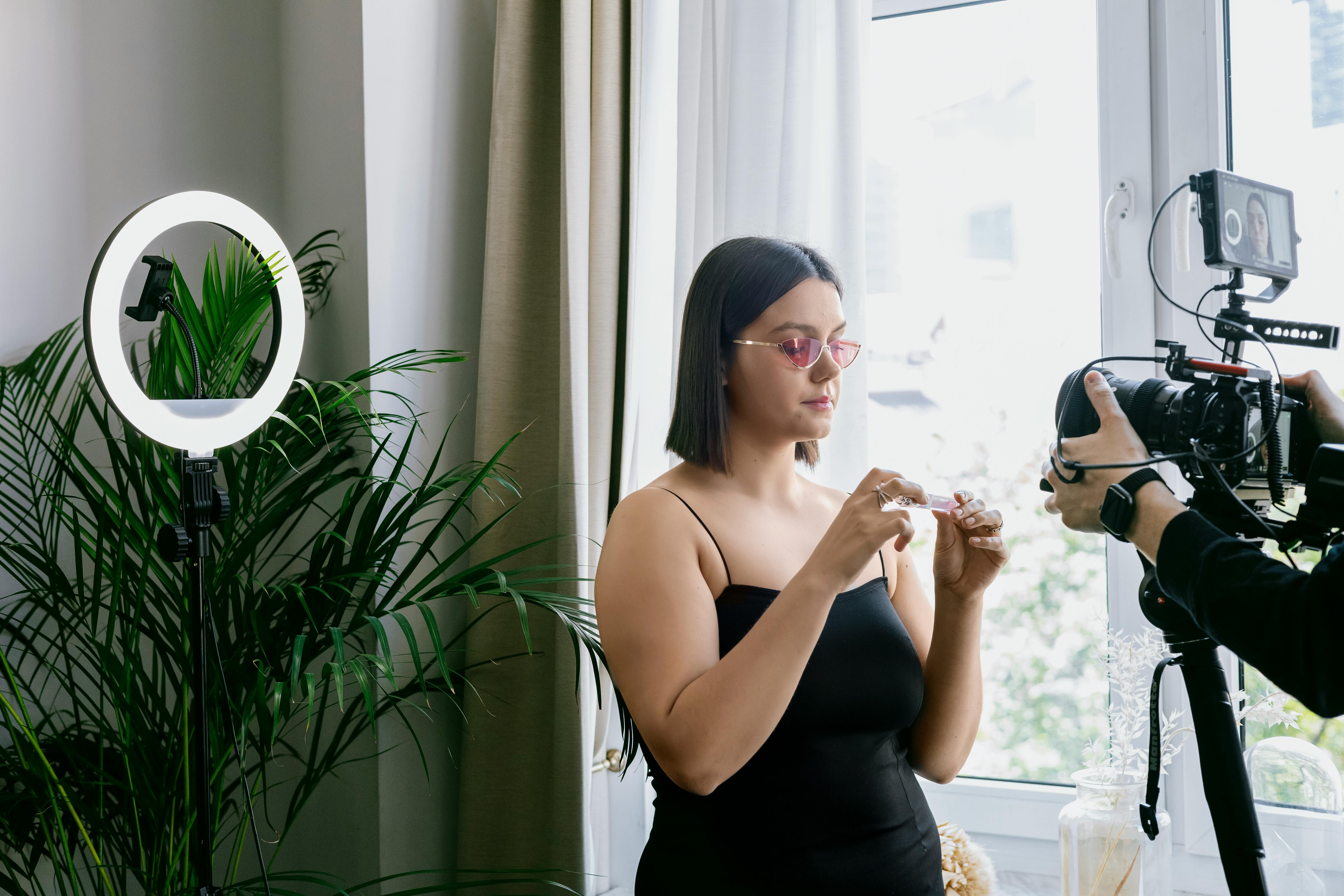 woman wearing black tank top and sunglasses while vlogging