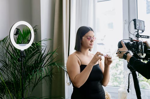 Woman Wearing Black Tank Top and Sunglasses while Vlogging