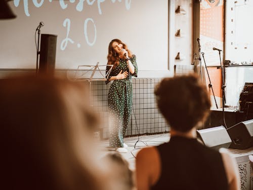 A Woman Wearing Polka Dots Jumpsuit while Singing on the Stage