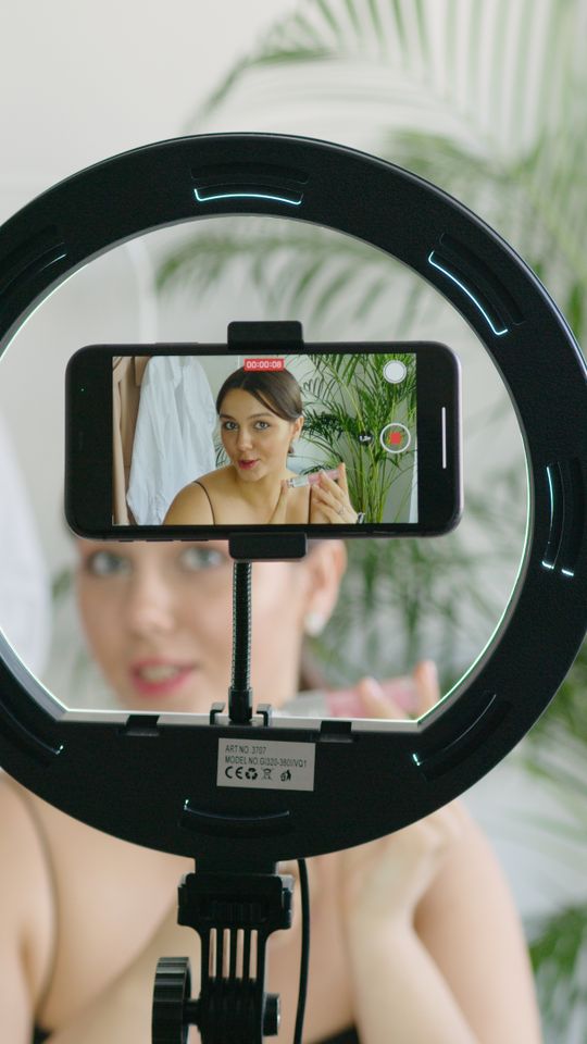 Créatrice face à son téléphone sur lampe annulaire