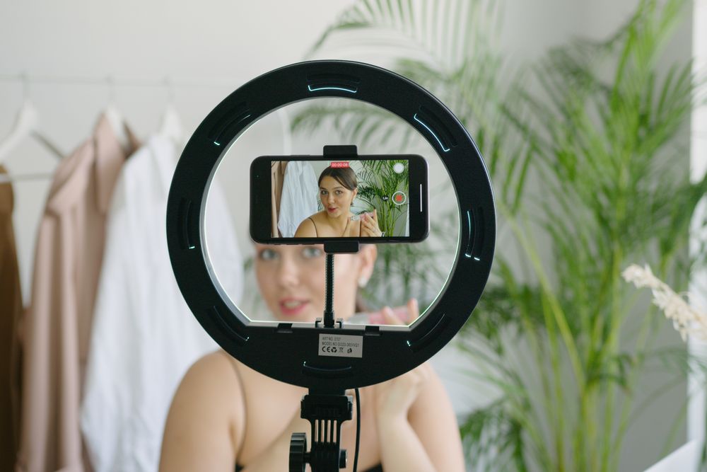 Creator filming herself on a phone with a ring light