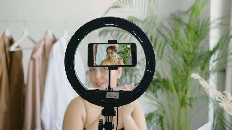 A Woman Video Recording Herself Using A Cellphone Camera