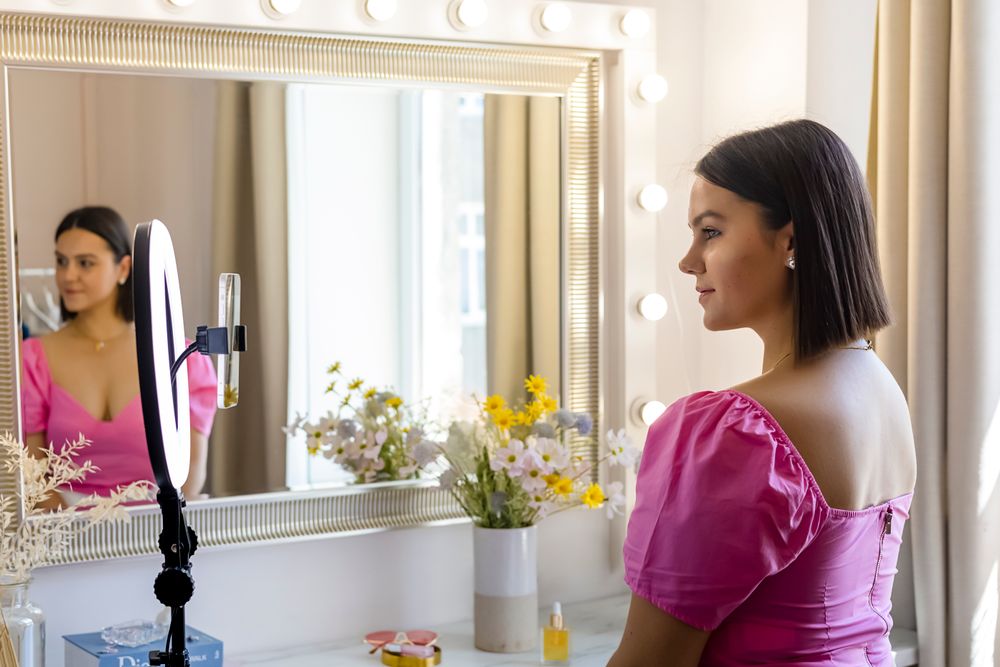 Client filming at a mirror in a styling and beauty setup