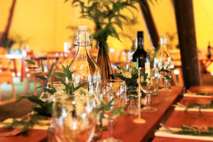 Wine Glasses And Wine Bottles On Top Of Brown Wooden Table