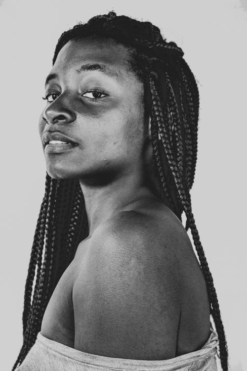 Free Artistic black and white portrait of a woman with long braided hair looking confidently. Stock Photo