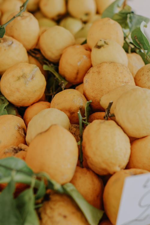 Free A close-up of fresh organic lemons with green leaves, showcasing vibrant yellow hues. Stock Photo