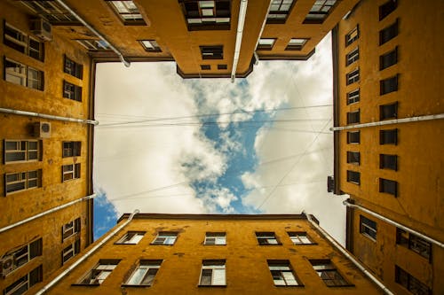 Free Brown Concrete Building Under White Clouds and Blue Sky Stock Photo