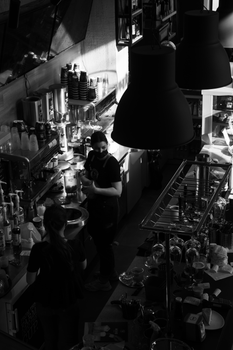 A captivating monochrome view of baristas working in a stylish coffee shop from above.
