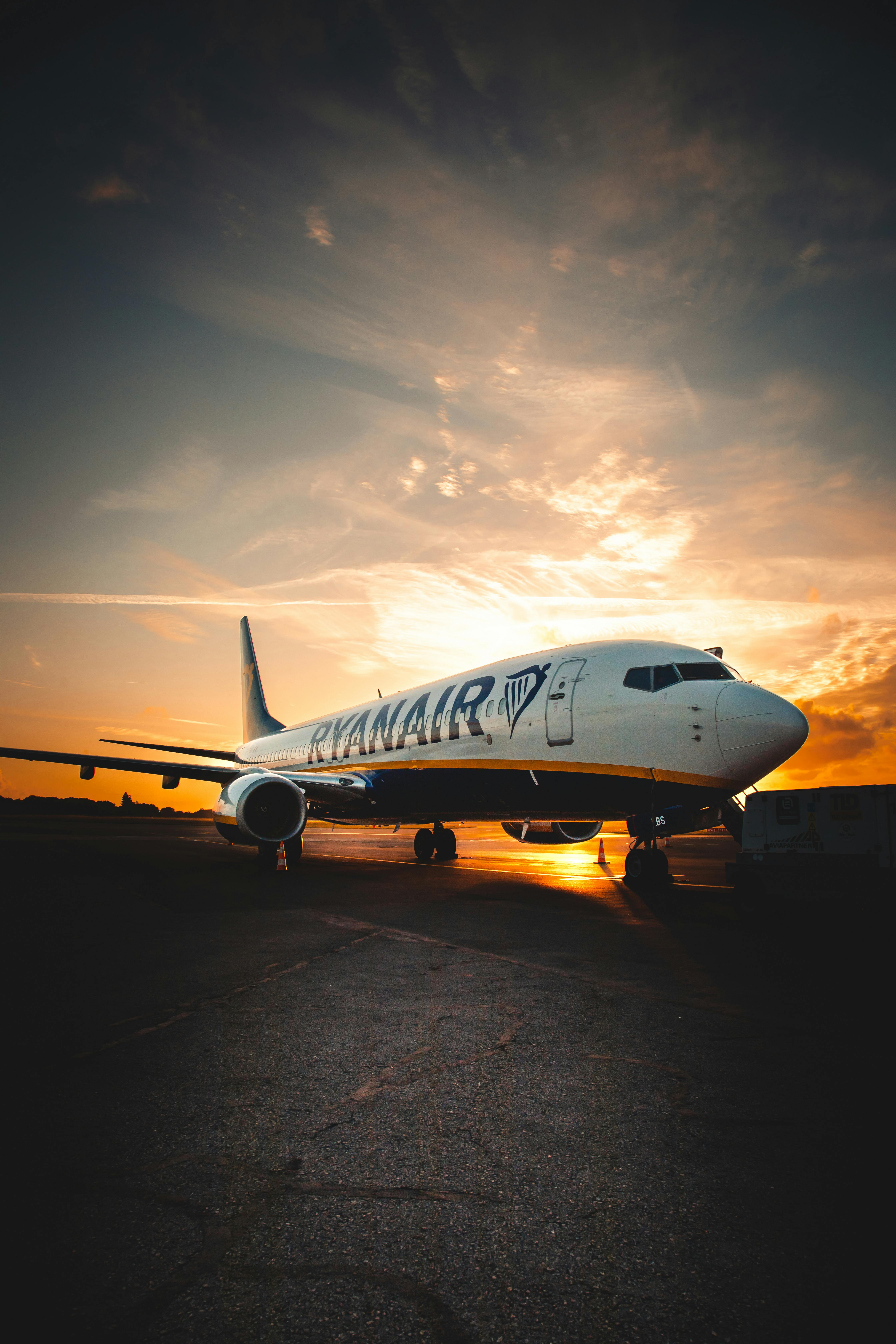 A Ryanair airplane on the tarmac of Nantes Airport at sunset, showcasing a dramatic sky.