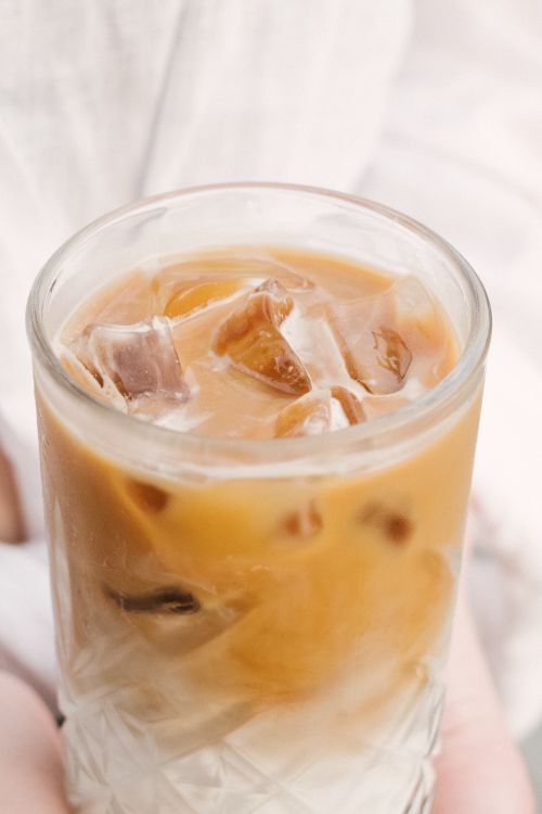 Free Close-up of creamy iced coffee with ice cubes in a clear glass, perfect for a cool refreshment. Stock Photo
