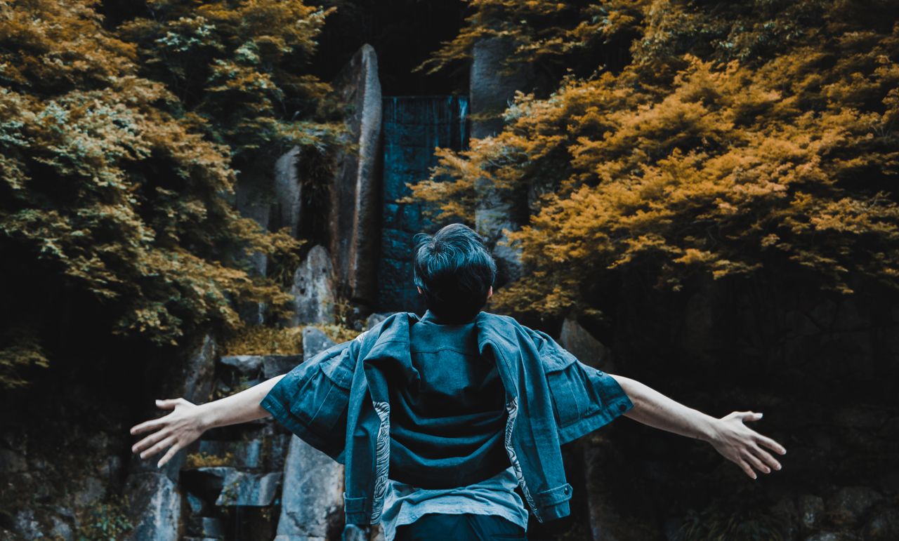 a man enjoying the scenic waterfall and lush autumn foliage in takahas