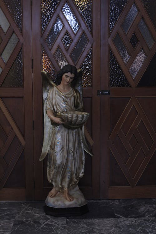 Statue of an Angel Near Wooden Doors