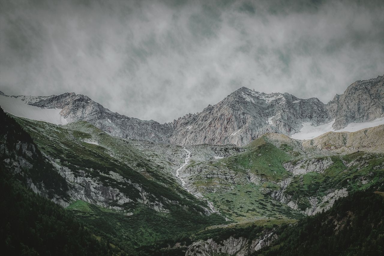 breathtaking view of a mountainous landscape with misty clouds and lus