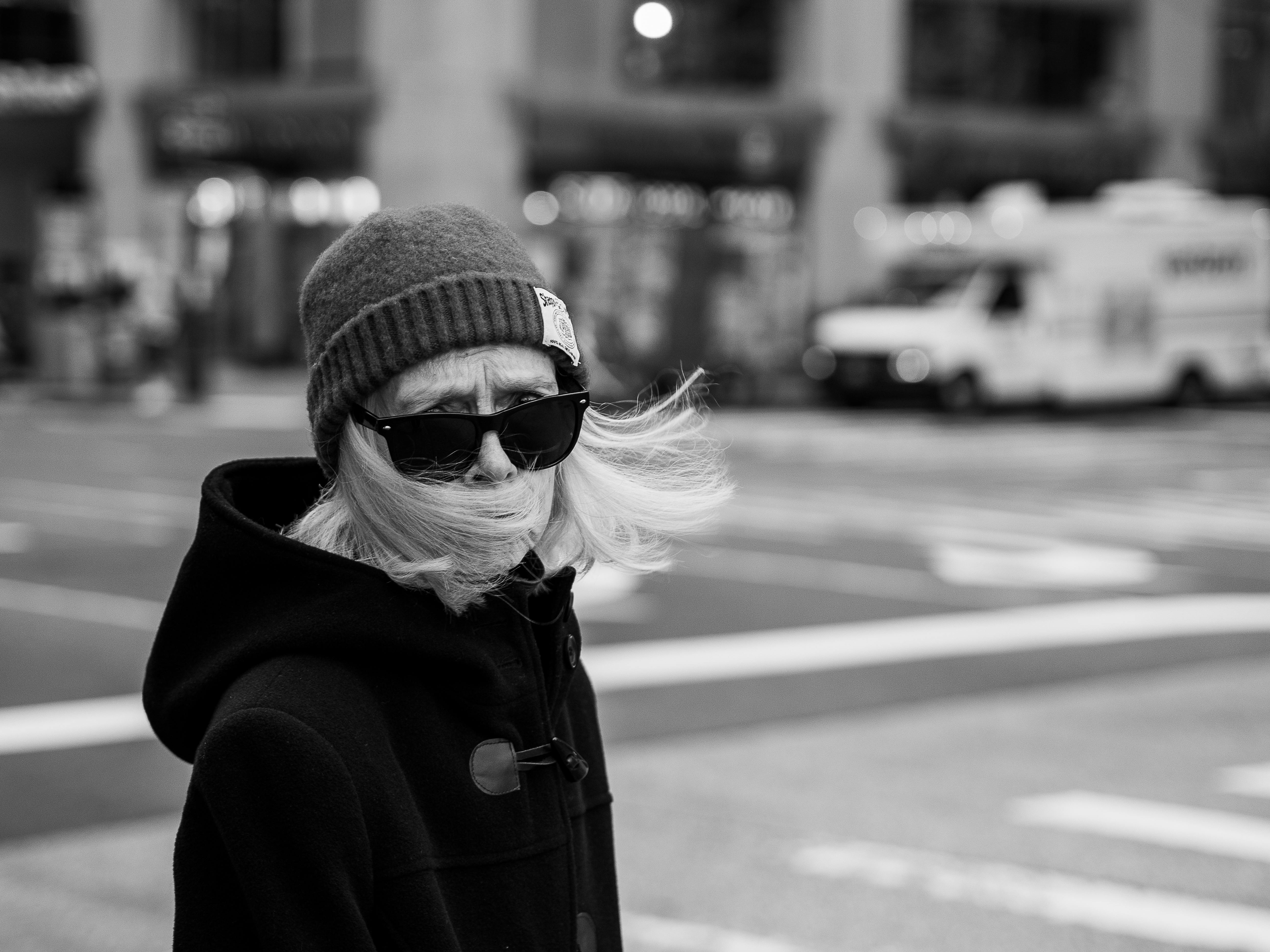 Grayscale Photography of a Woman Wearing Beanie and Sunglasses Standing