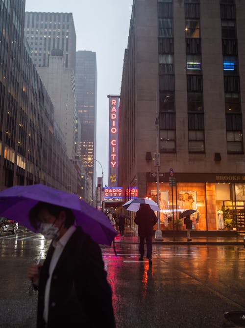 People Walking on the Street While Holding Umbrellas on a Rainy Day