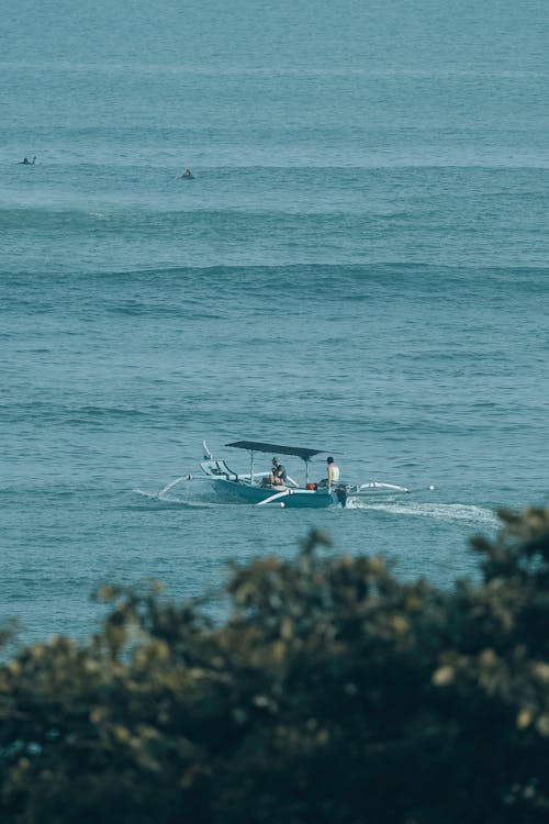 People Riding a Blue Boat on the Sea