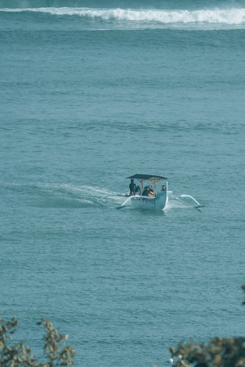 People Riding a Blue Boat on the Sea