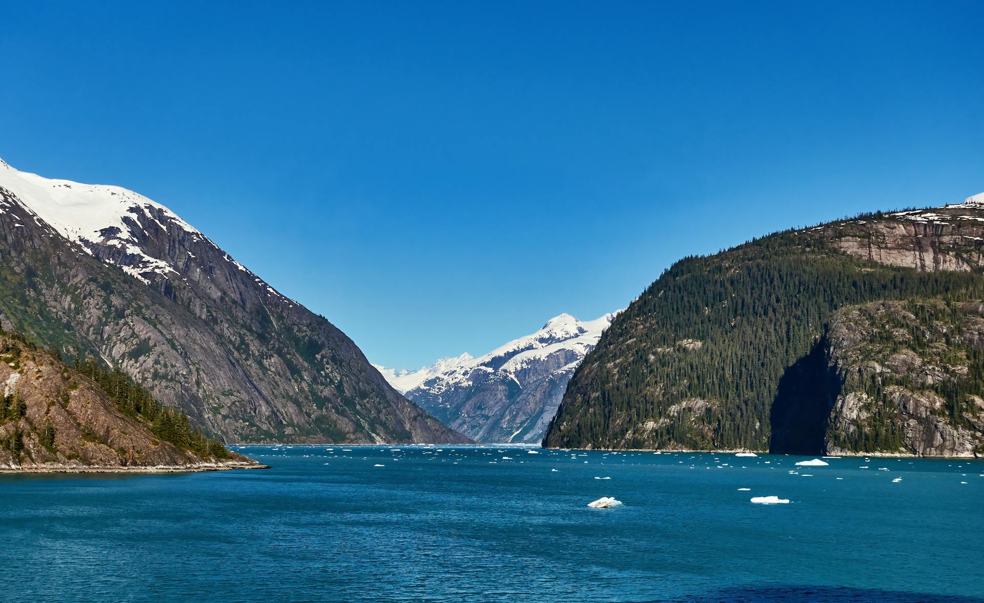Breathtaking view of a fjord in Alaska with snowcapped mountains and crystal blue water.