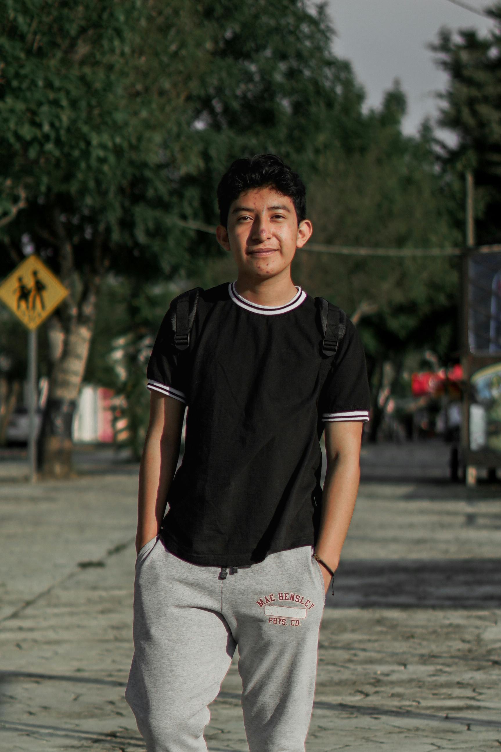 Casual portrait of a young man standing outside on a sunny day.