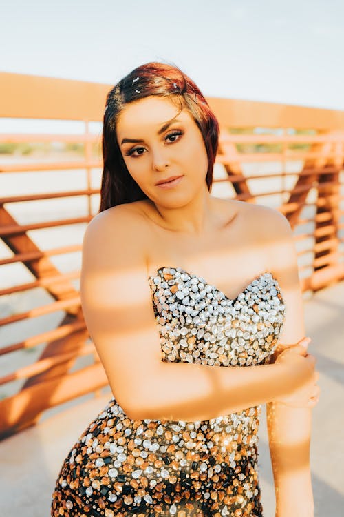 Woman in Beaded Tube Top Near Metal Railing