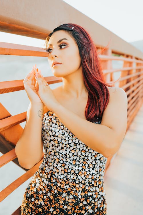 A Beautiful Woman in Beaded Top Near Metal Railing