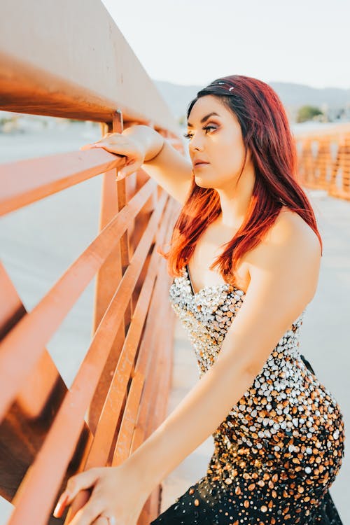 Beautiful Woman Leaning on a Metal Fence