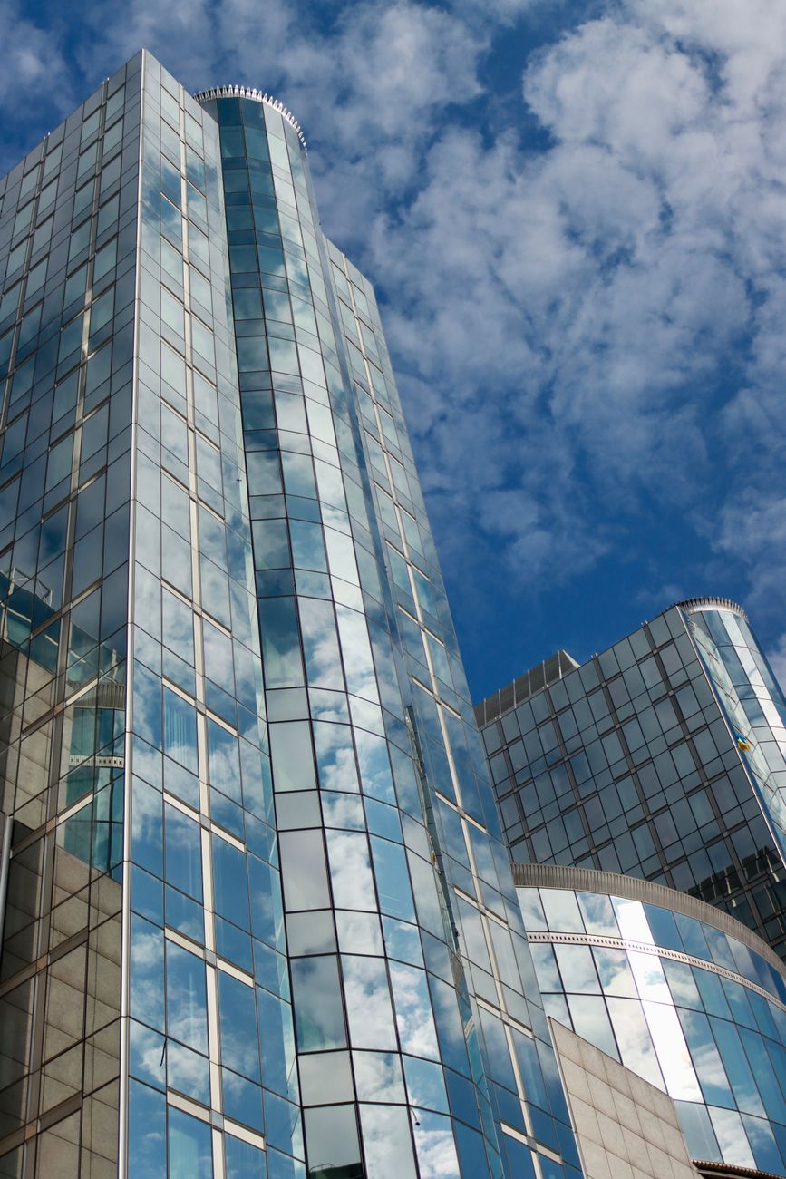 Fachada de vidro em Gravataí/RS de prédio comercial refletindo céu azul — Oliveira Vidros
