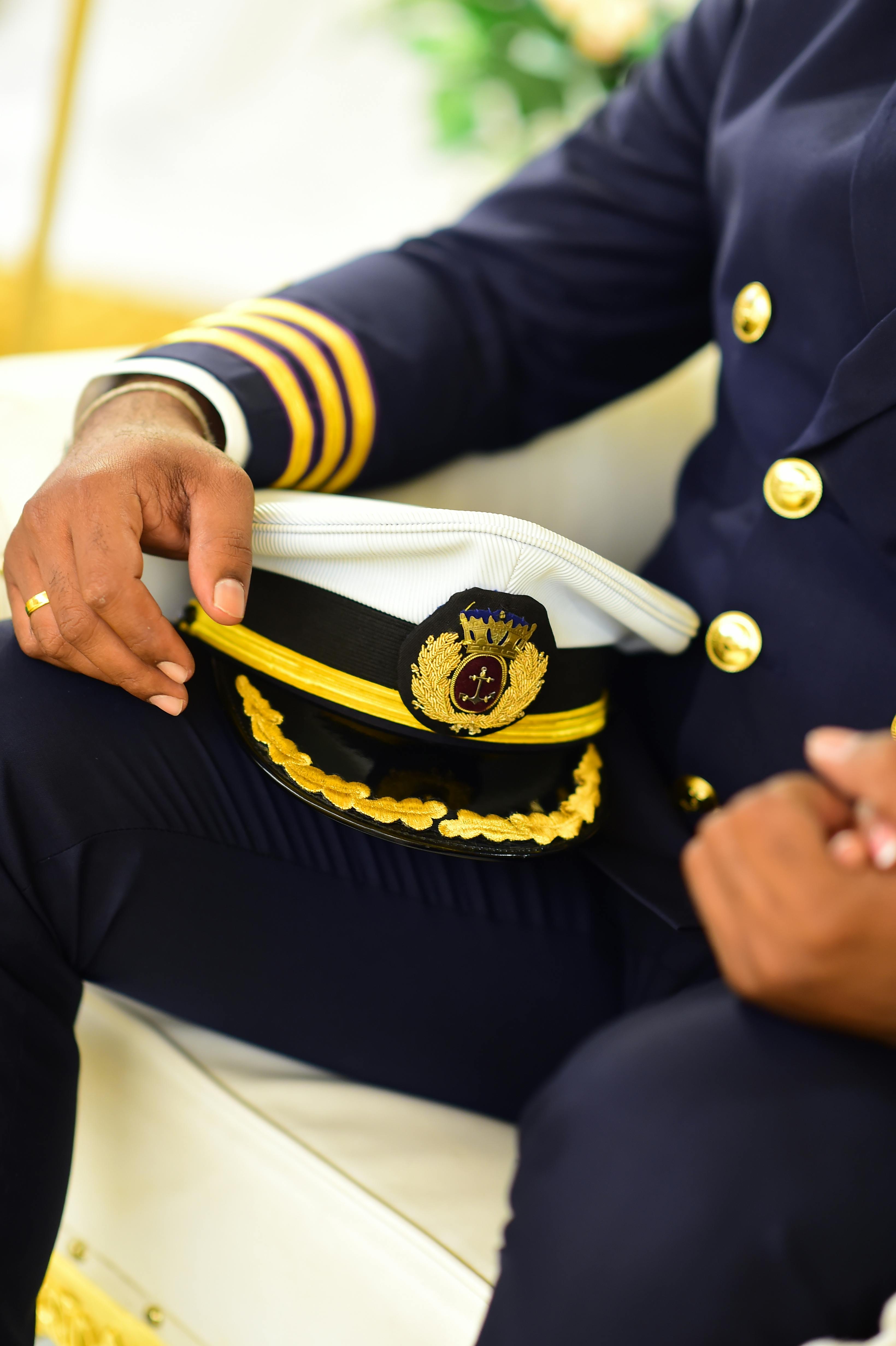 man holding a captain hat