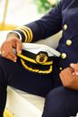 Man Holding a Captain Hat