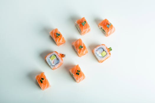 Fresh salmon sushi rolls arranged on a minimalist white background, showcasing traditional Japanese cuisine.