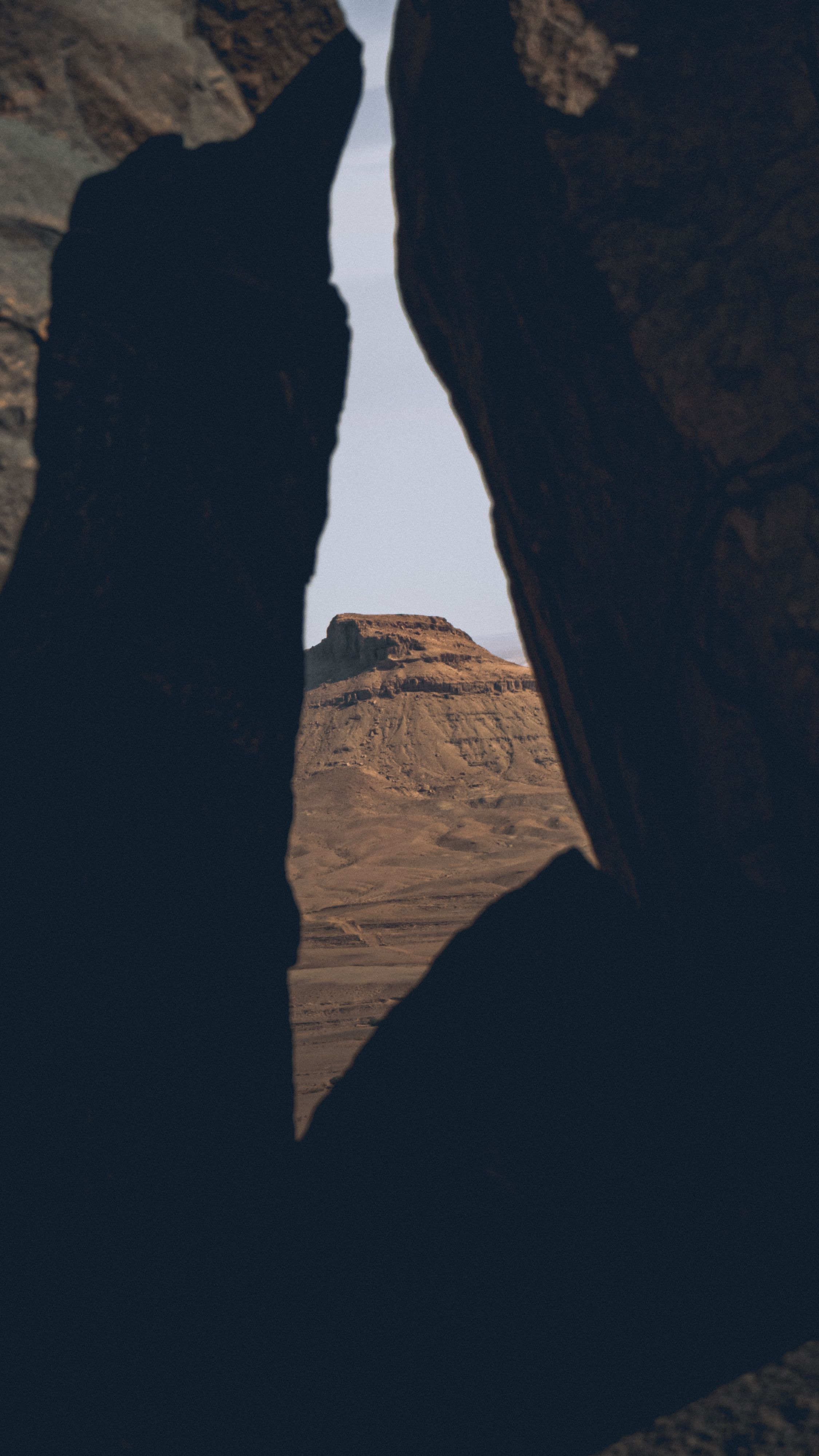 Dramatic view of a geological rock formation through dark boulders in Algeria.