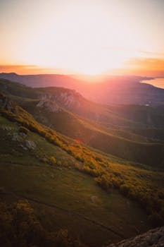 Breathtaking view of sunrise over mountains and valleys with vibrant colors and serene atmosphere.