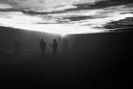 黄昏时分，户外雾气缭绕，人物剪影营造出一种神秘的氛围