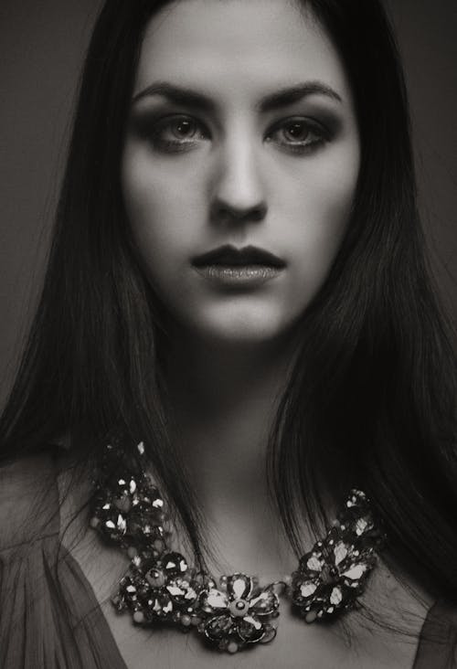 Grayscale Photo of Woman Wearing Floral Necklace