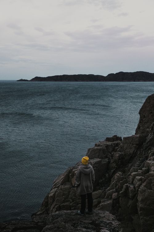 Free A serene scene of solitude with a person overlooking the rocky coast of Teriberka, Russia. Stock Photo