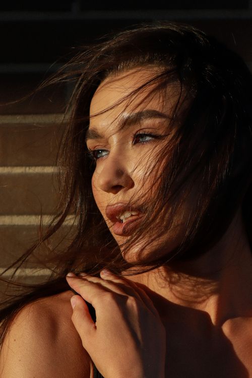 Free Stunning brunette woman captured during golden hour, showcasing natural beauty with flowing hair. Stock Photo